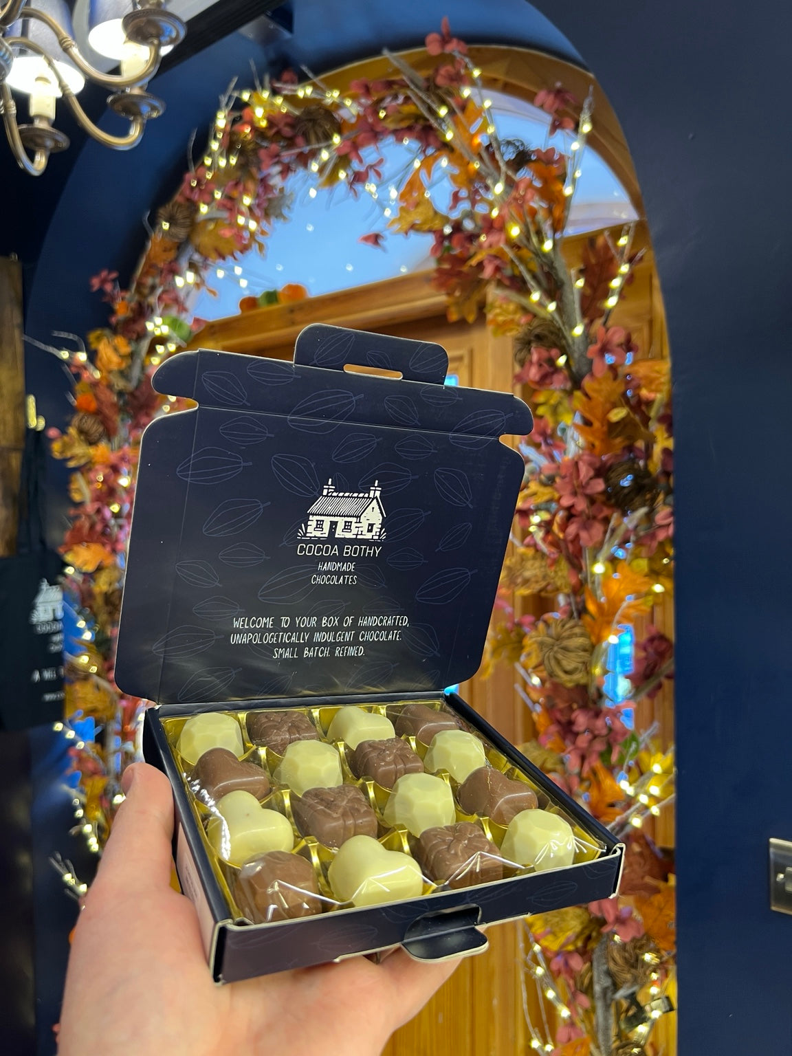 Cocoa Bothy 16-piece Belgian chocolate selection box featuring milk and white chocolates in an open navy gift box at the Steeple, Inverness